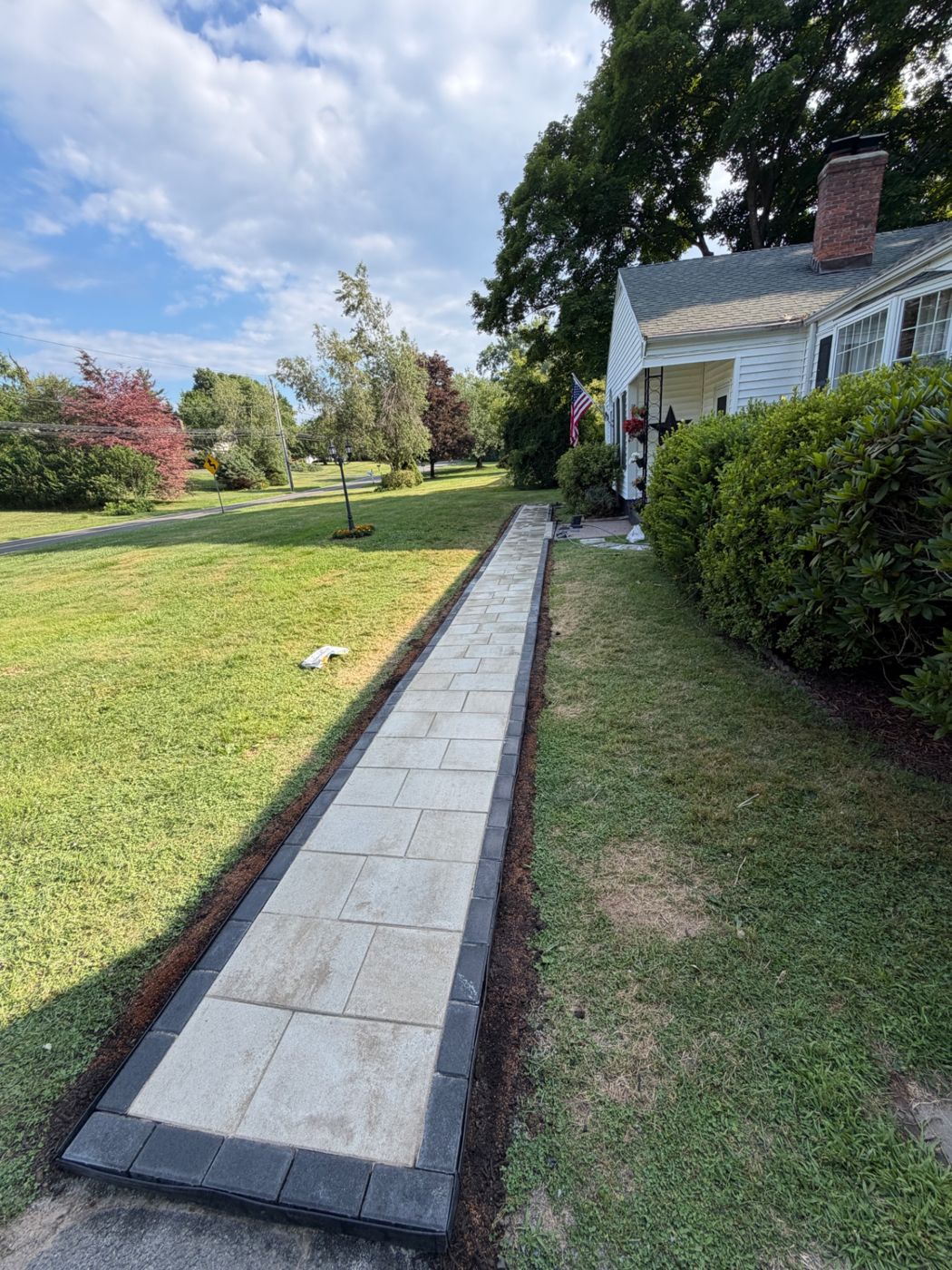 Completed light-colored paver walkway with dark borders
